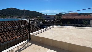 A rooftop terrace with a view of a body of water and hills in the distance. - Beautiful place  on the beach with gorgeous views, close to the restaurants. (Vinišce)