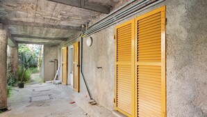 A corridor with yellow shutters, concrete walls, and visible pipes. - Apartment 'Levanto A 50 Metri' with Private Terrace and Wi-Fi (Levanto)
