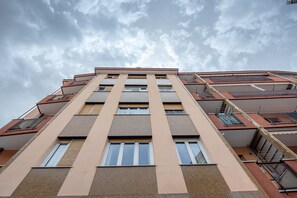 Un immeuble à plusieurs étages doté de balcons, de grandes fenêtres et d’un toit plat.