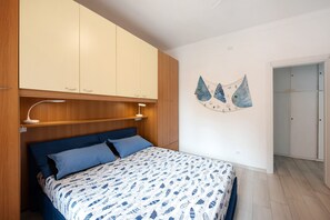 Une chambre à coucher avec un lit, une armoire en bois et un élément décoratif mural.