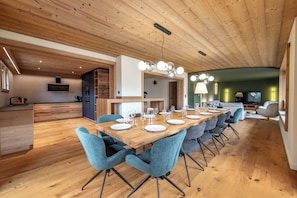A modern dining area with a wooden table set for six, surrounded by blue chairs. - L'Alcôve Gîte & Spa - Chalet with swimming pool (Xonrupt-Longemer)