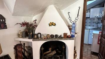 Una cocina con chimenea integrada, una mesa de madera y una encimera.