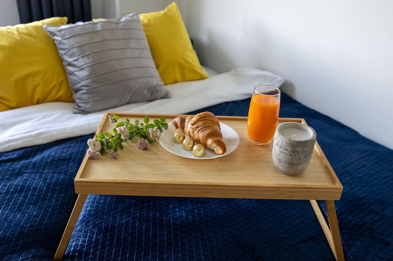 Ein Frühstücksbrett mit Croissants, einem Glas Orangensaft und einer Keramiktasse.