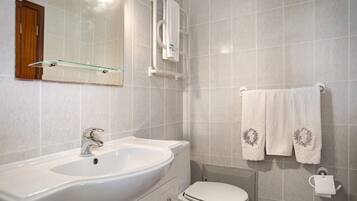 A bathroom with a white sink, toilet, and towel rack.