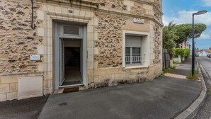 A stone building with a door, a window, and a sign that reads 'RUE DU CAPITAUT.'