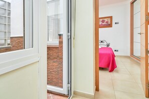 Une pièce comprenant un lit, une porte-fenêtre coulissante donnant sur un espace extérieur et une petite fenêtre.