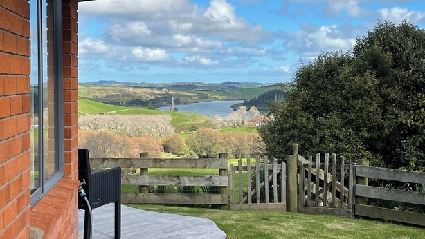 Eine Terrasse mit Blick auf einen See und Hügel.
