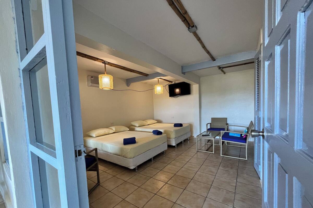 Een hotelkamer met twee bedden, een televisie, een klein tafeltje en een stoel.