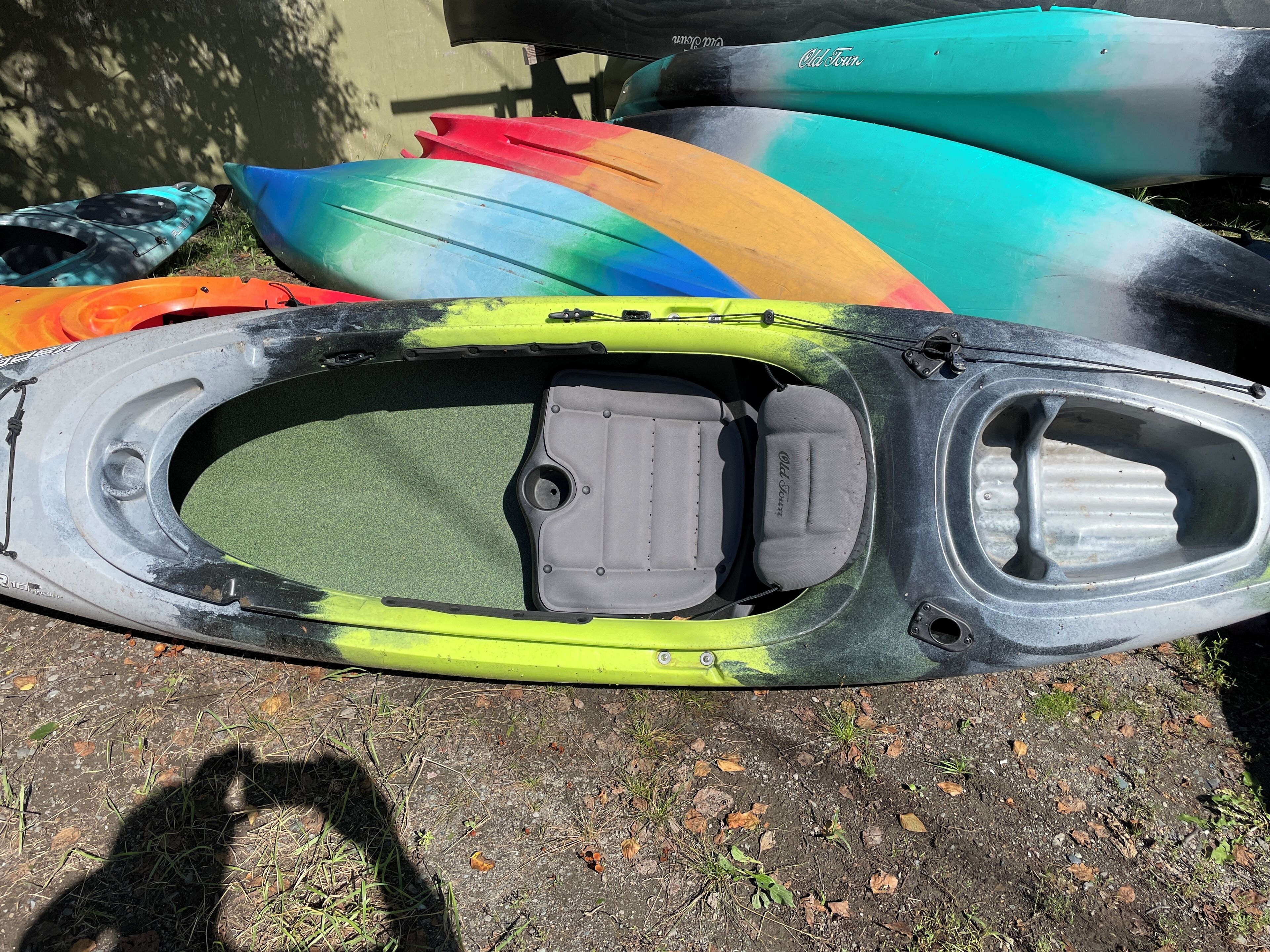 Kayak con sedile verde e vano portaoggetti grigio.