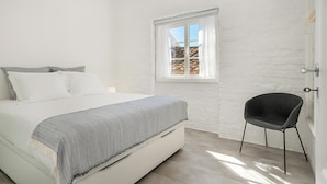Une chambre à coucher avec un lit, une fenêtre et une chaise.