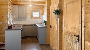 A wooden interior with a kitchen area, a window, and a door. - 2 bedroom accommodation in Seascale, near Gosforth and Wasdale (Seascale, near Gosforth and Wasdale)