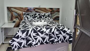 1 habitación, tabla de planchar con plancha y ropa de cama