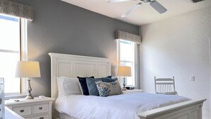 A bedroom with a white bed, two bedside tables, a nightstand, a ceiling fan, and a window with a view. - 4BR Villa Bright and Spacious w/ Pool (Davenport)
