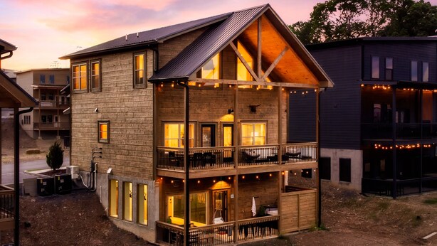 A multi-story wooden building with balconies and large windows, featuring a rustic architectural style. - WizardsWelcome~FallSale~HarryPotter~Heated Indoor Pool~HotTub~5minstoPkwy (Pigeon Forge)