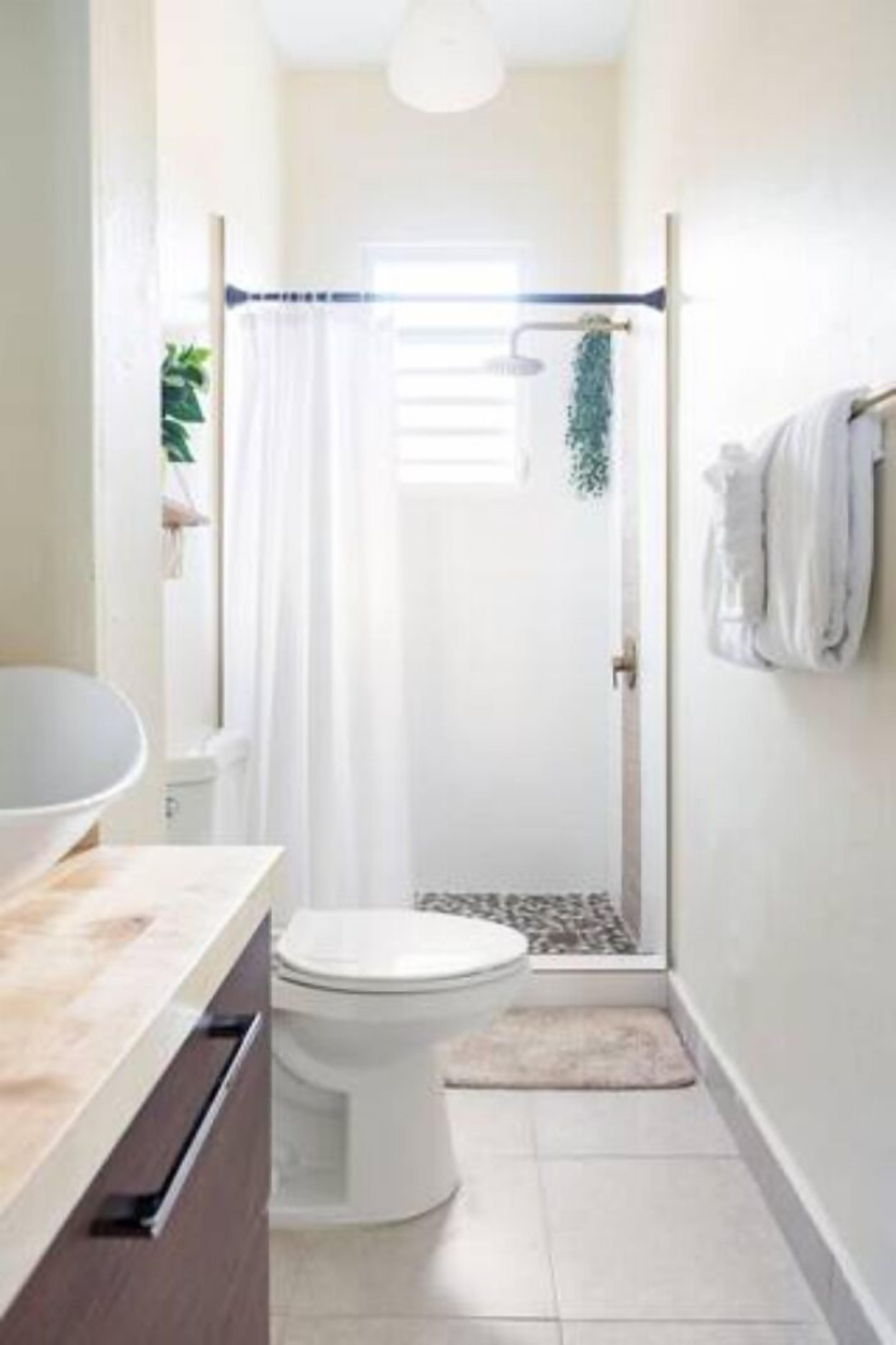 Une salle de bain comprenant des toilettes, un lavabo et un espace douche.