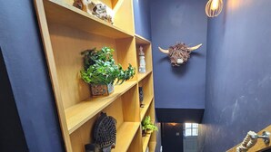 Un intérieur moderne avec des étagères en bois, un objet décoratif en forme de corne et un escalier.
