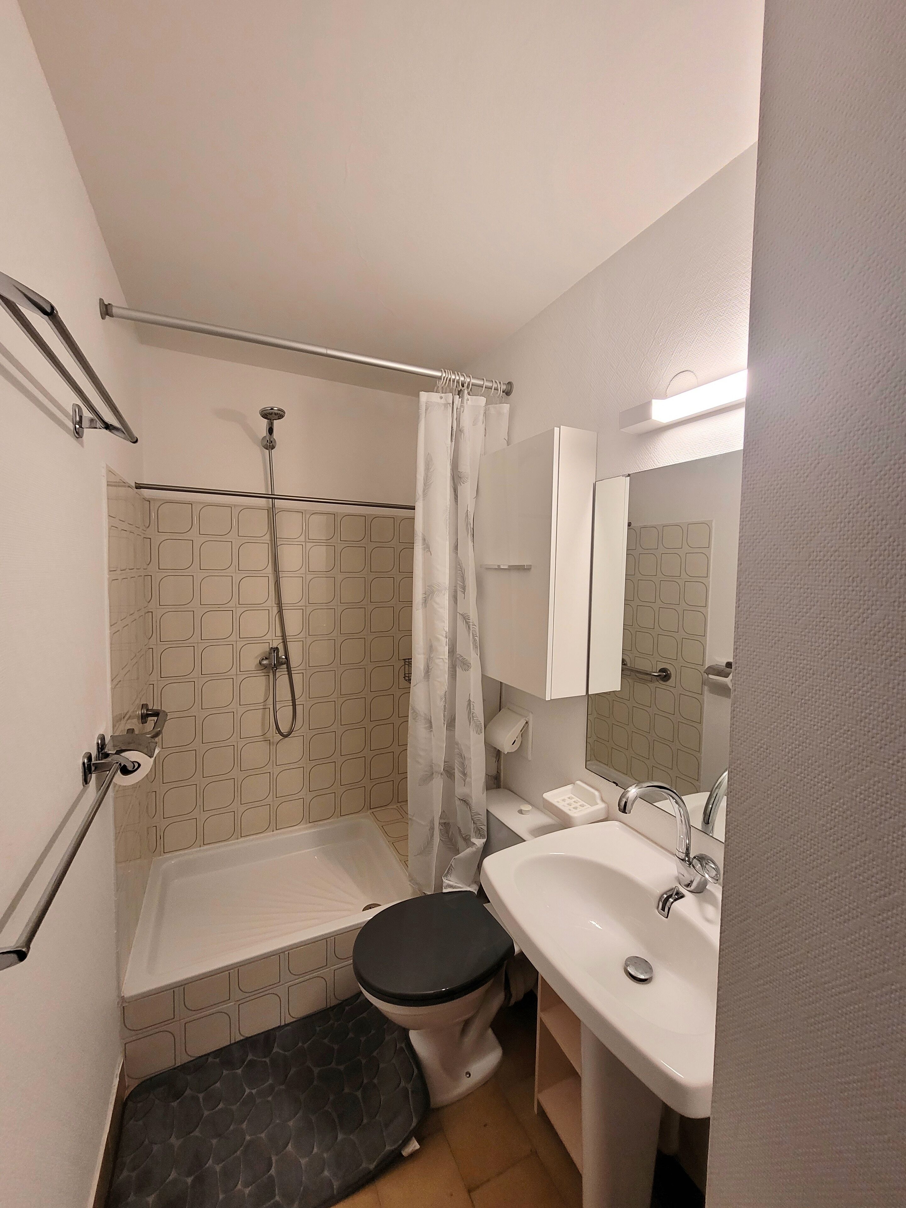 Et badeværelse med badekar, toilet og håndvask.