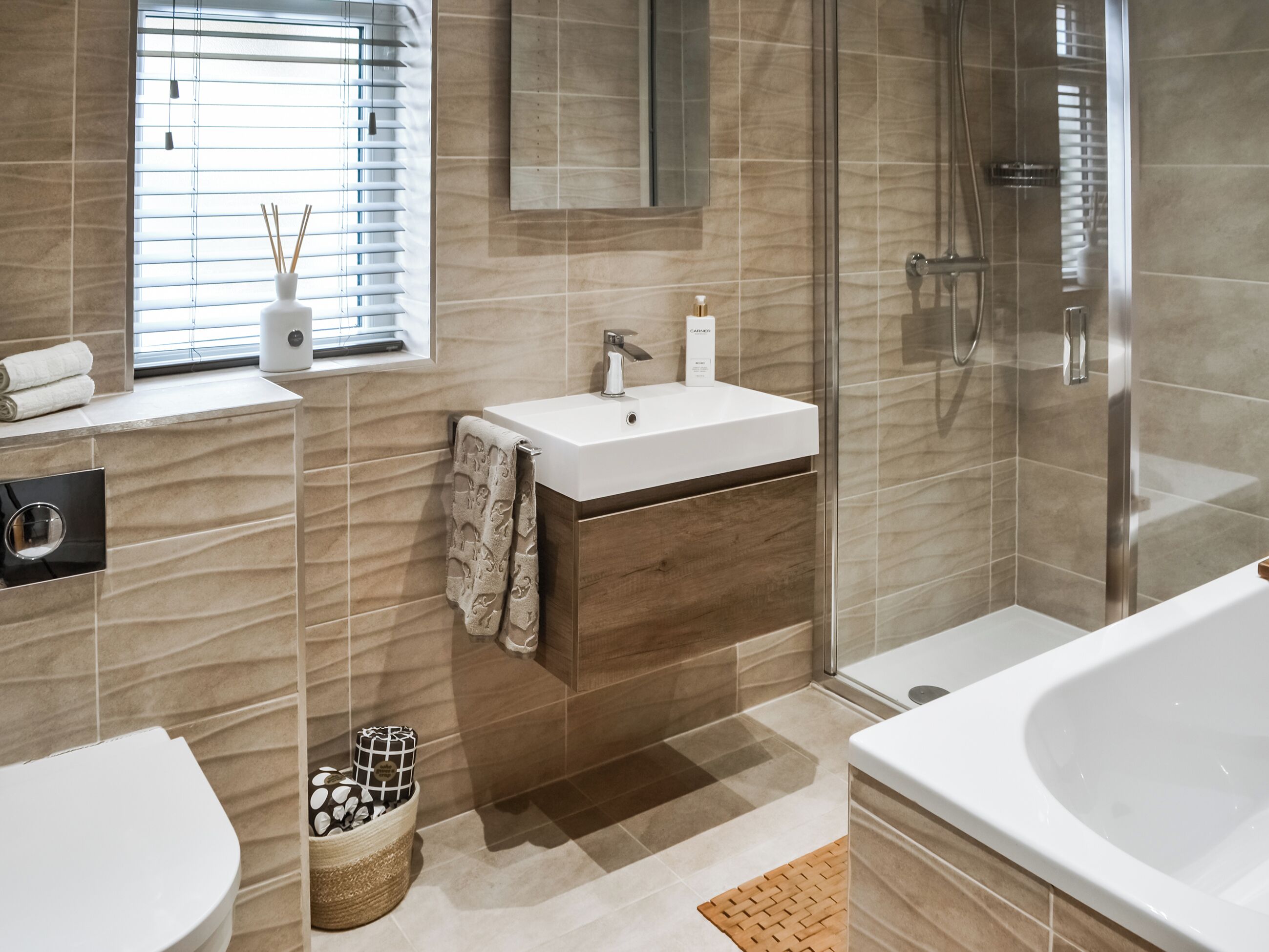 A modern bathroom with a glass-enclosed shower, a white sink, and a large bathtub.