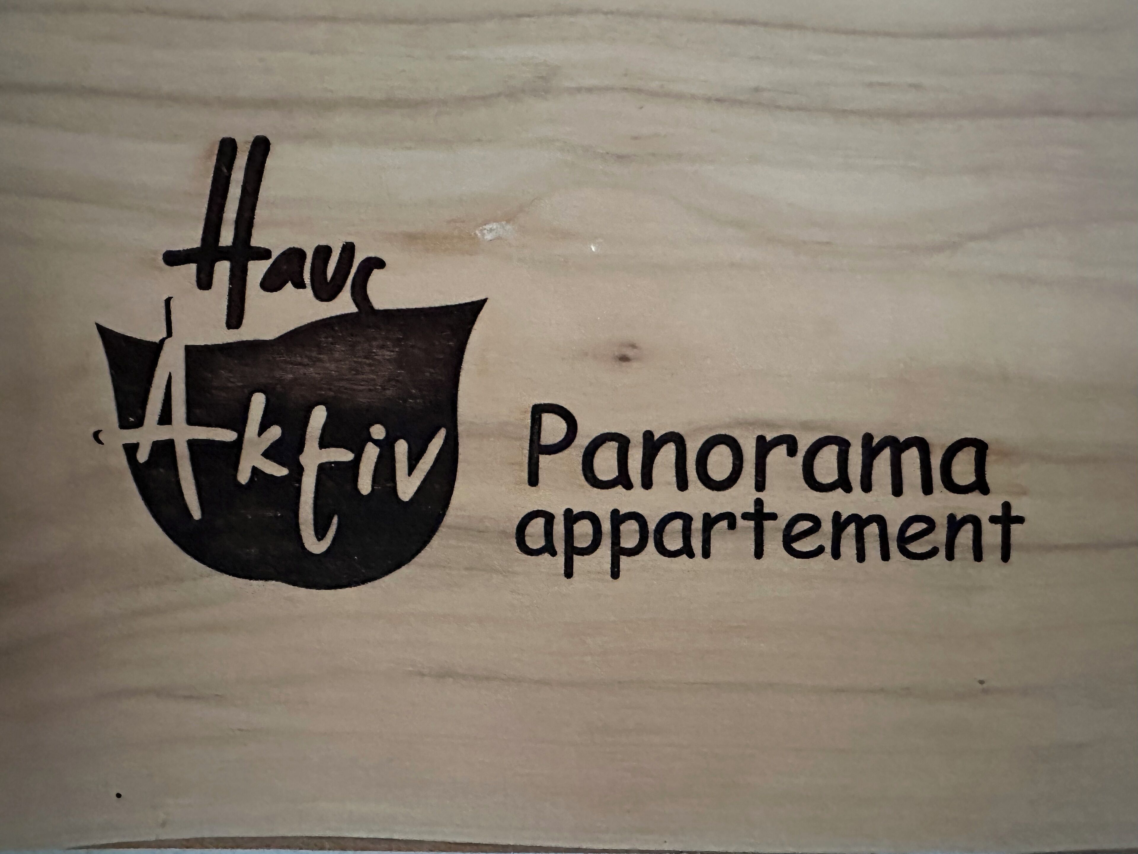 A wooden sign with the text "Hav Aktiv Panorama appartement".