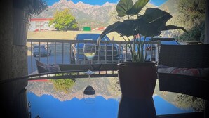 A view from a balcony with a clear reflection of mountains and a car in the background. - Modern Dream @ Fairmont (accessible entrance) (Fairmont Hot Springs)