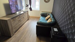 Une petite chambre comprenant un lit, une télévision, une commode et une fenêtre.