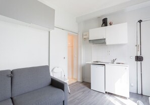 Cozy living space with a sofa, dining table, and kitchenette.