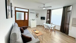 Un salon moderne comprenant un canapé, une table basse et un coin repas avec une table et des chaises.