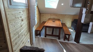 Ein kompakter, moderner Raum mit einer Holzbank, einem kleinen Tisch und einem Oberlicht.