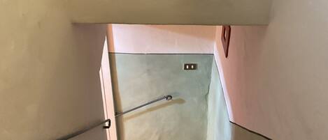 Eine Treppe mit Handlauf, einer Wandplatte und einer kleinen Steckdose.