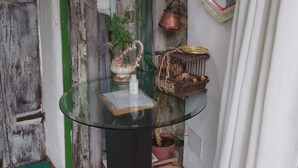 A glass table with a book, a vase with flowers, and a basket of fruits. - Stella's House Bed & Breakfast  (Sabbio Chiese)