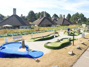 Un jardin aménagé avec une piscine, des bancs et un sentier.