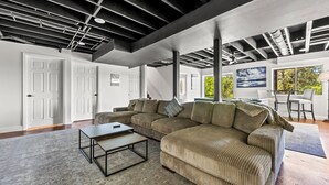 A modern living room with a sectional sofa, a coffee table, and a view of the outdoors.