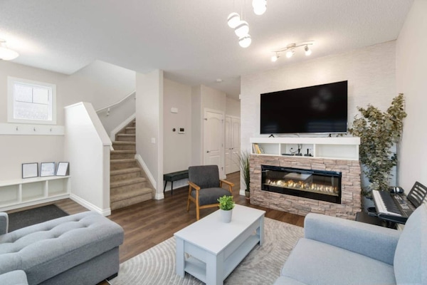 Main Floor Living Room with Basement Living Room with Video Game Machine and 65" 4K UHD HDR LED Roku Smart TV