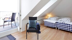 A room with a bed, a chair, and a balcony. - 8 Person Holiday Home on a Holiday Park in Karrebaeksminde (Karrebæksminde)