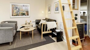 A modern living room with a sofa, armchairs, a coffee table, and a ladder. - 4 Person Holiday Home in Aeroskobing (Aeroskobing)