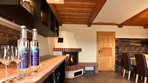 A cozy room with a wooden ceiling, a fireplace, and a dining area with chairs and a table. - Apartment in St. Stefan im Rosental (Sankt Stefan im Rosental)