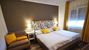 A hotel room with a bed, a sofa, a nightstand, and a window with curtains. - Apartment in St. Stefan im Rosental (Sankt Stefan im Rosental)