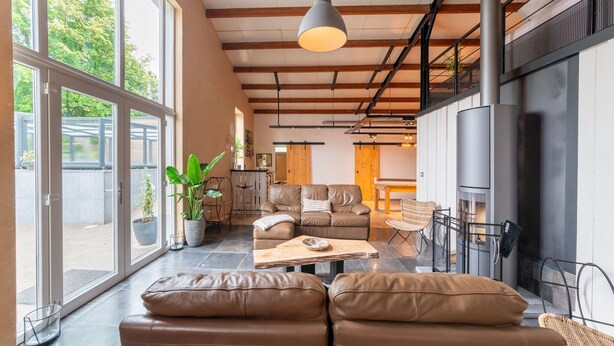 Ein modernes Wohnzimmer mit Sofa, Couchtisch und Kamin.