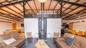Ein geräumiger Wohnbereich mit Ledersofas, einem zentralen Holztisch und einem modernen Kamin.