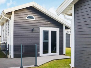 A modern house with a dark grey exterior, white trim, and a large sliding glass door.