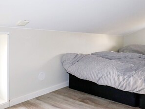 A bedroom with a bed, a window, and a wall socket.