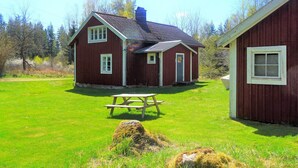 A red wooden house with a chimney, a picnic table, and a grassy yard. - 6 Person Holiday Home in Tingsryd-by Traum (Tingsryd)