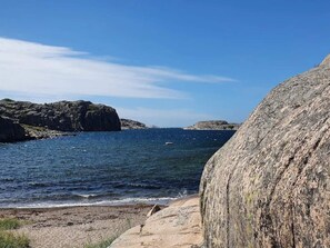Et kystlandskab med stengrund og en klar blå himmel.