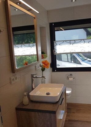 A modern bathroom with a rectangular sink, a mirror, and a window. - Holiday Home Kupa Comfortable Vacation Home (Burg (Spreewald))