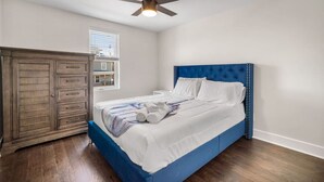 A bedroom with a bed, a wardrobe, and a ceiling fan.