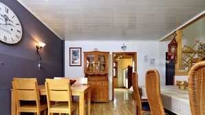 A dining area with wooden furniture, a wall clock, and a cabinet. - Holiday Home Near Winterberg Ski Slopes (Olsberg)