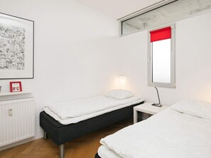 A small, clean room with a bed, a desk, and a radiator. - 6 Person Holiday Park Home in Blokhus (Blokhus)