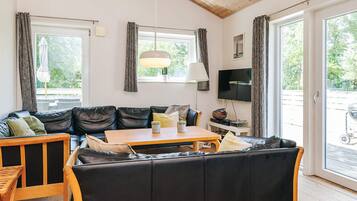 Een gezellige woonkamer met een bank, een houten salontafel en een televisie.