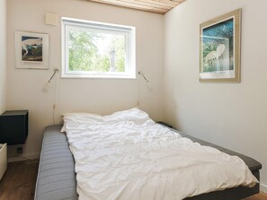 A bedroom with a single bed, a window, and two framed artworks on the walls. - 12 Person Holiday Home in Rodby (Rodby)