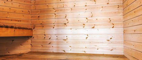 A sauna room with wooden walls and benches.